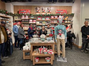 Guests smiling as they shop in the Disney holiday merchandise section of Mickey’s of Glendale.