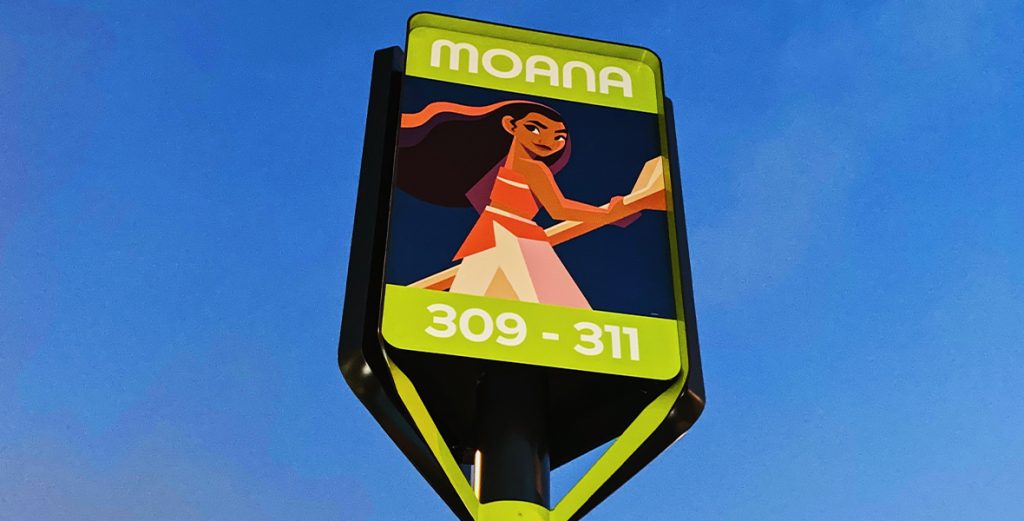 A sign with animated character Moana on a metal post.