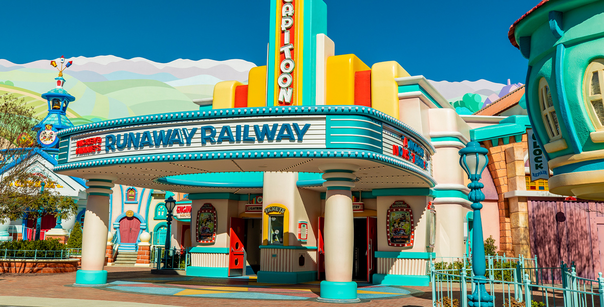 The front of the “El CapiTOON” Theatre, a yellow, red, and teal movie theater with a marquee featuring “Mickey & Minnie’s Runaway Railway” in red text.