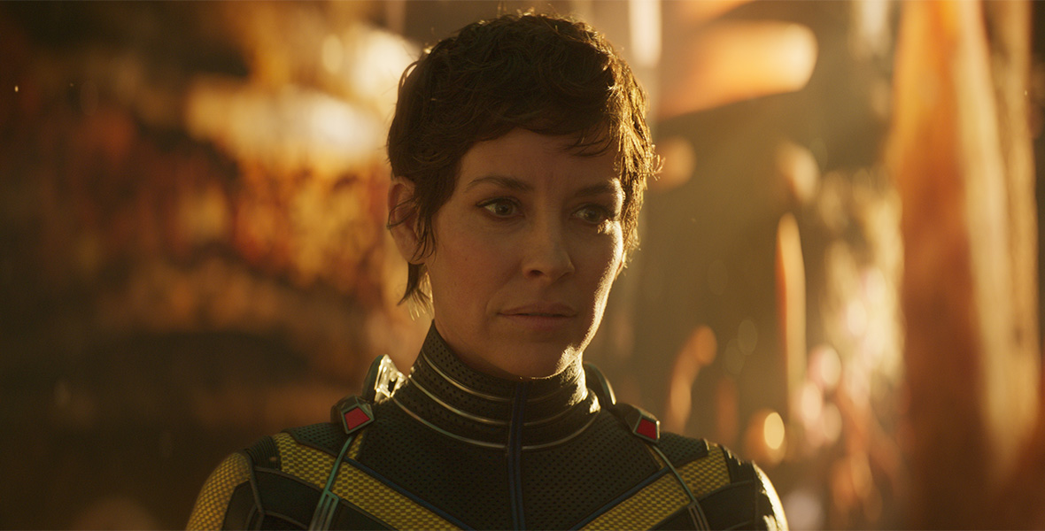 A headshot of Hope Van Dyne clad in her yellow suit. She has short black hair styled in a pixie cut, staring with an unreadable expression off-screen.
