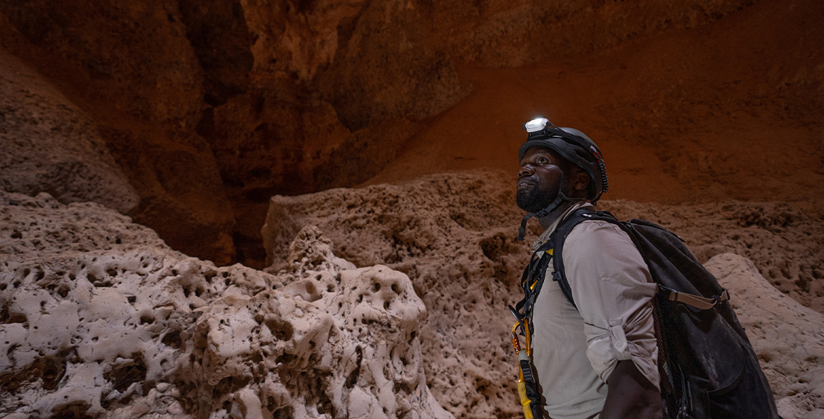 In a scene from an episode of 7 Toughest Days, Dwayne Fields explores a massive cave in Oman.