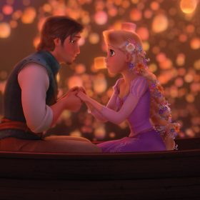 In the animated film Tangled, Rapunzel and Eugene sit in a small boat together as they hold hands and look into each other’s eyes. Rapunzel’s blond hair is braided back with vibrant flowers, and she wears a purple dress with small, puffed sleeves. Eugene wears a white long-sleeved shirt with a green vest. Behind them, the night sky is lit up with hundreds of glowing lanterns that float above them and drift on the water.