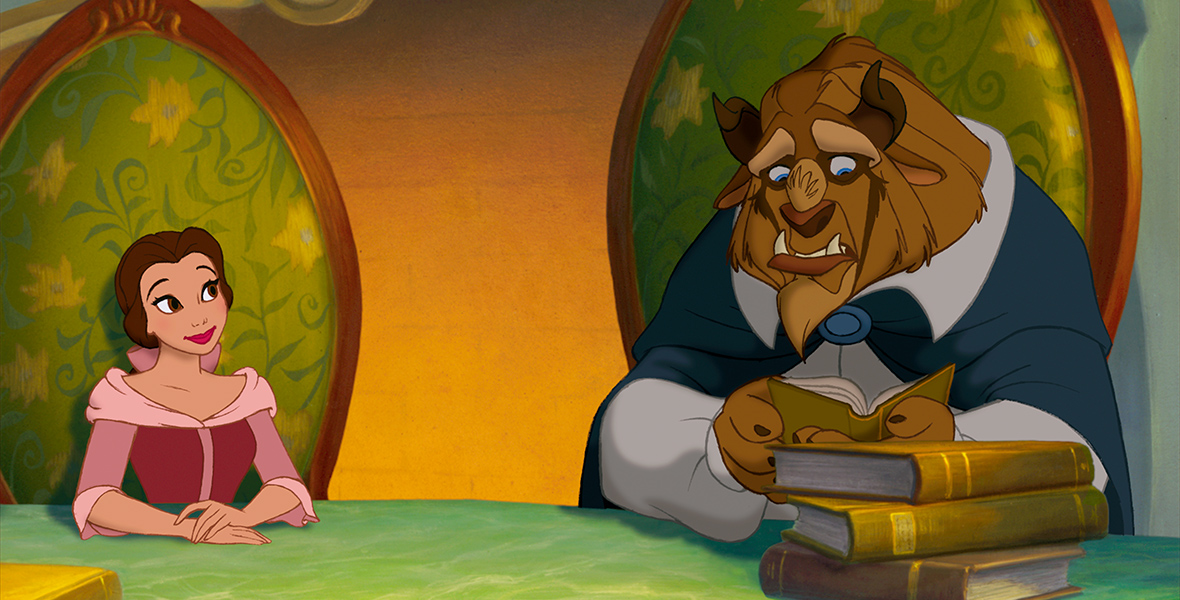 The animated Belle and Beast sit side-by-side in large green floral chairs, four books on the table in front of them. Beast looks nervously down at the open book he holds as Belle smiles at him. Beast wears a blue cloak while Belle dons a pink dress, her brown hair pulled back in a pink bow.