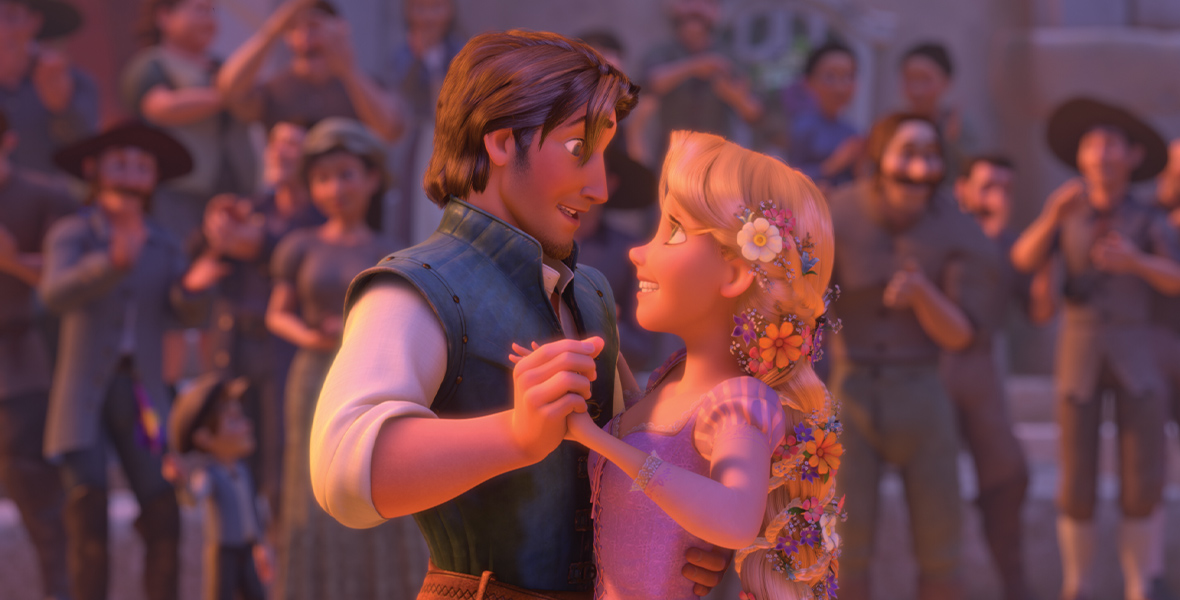 In the animated film Tangled, Rapunzel and Eugene dance in the town with blurry onlookers behind them. They face each other hand-in-hand and look into each other’s eyes.