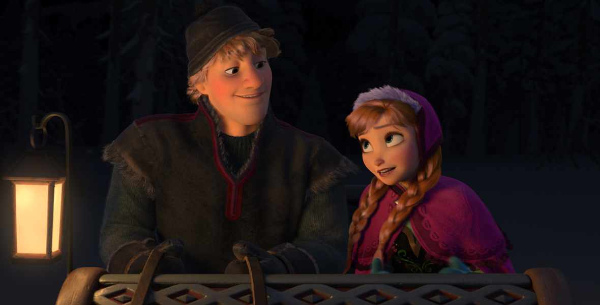 At night, the animated Anna and Kristoff ride together in a sled, a glowing lantern beside them. Kristoff holds the reins and looks down at her, clad in gray winterwear. Anna’s red hair is split into two braids under a pink cap and matching cape.
