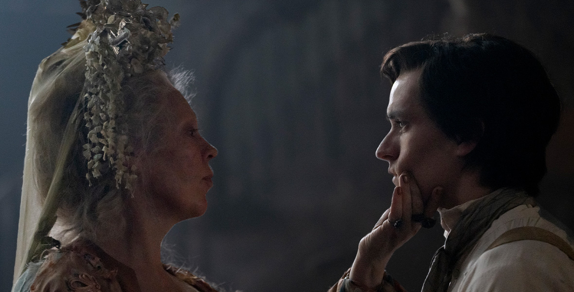 In a scene from an episode of Great Expectations, actor Olivia Colman grabs actor Fionn Whitehead’s chin as they stand face to face.