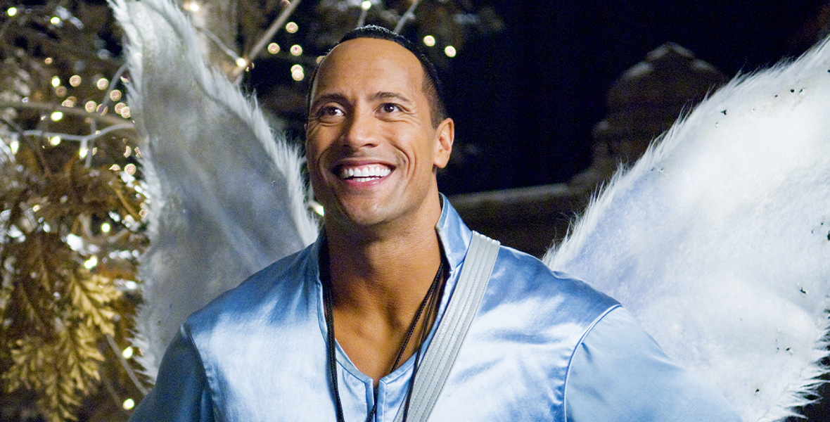 In a scene from Tooth Fairy, actor Dwayne Johnson wears a blue, silk long-sleeved top and large, white angel wings.