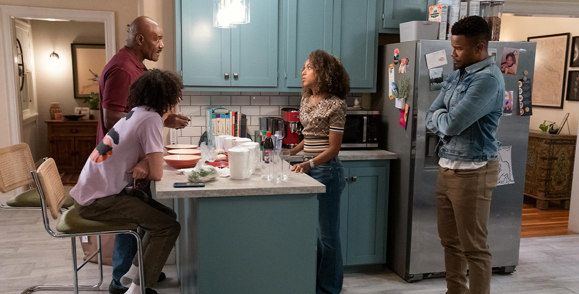 In a scene from an episode of UnPrisoned, actors Delroy Lindo, Kerry Washington, Faly Rakotohavana, and Marque Richardson gather around a kitchen island inside a residential home.