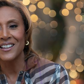 Robin Roberts wears a Burberry shirt, a gold necklace, and gold earrings.