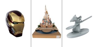 Left— Iron Man’s helmet, a shiny gold and dark red helmet stylized like the Marvel comics character of the same name. Middle— A model of Hong Kong Disneyland’s Castle of Magical Dreams, a pink and blue castle that resembles a combination of several castles from Disney princess films. Right— A gray maquette of Remy from Ratatouille, holding a spoon.