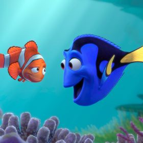 Marlin, an orange clownfish, and Dory, a blue tang, look at each other while floating above purple sea anemones. Marlin is looking with skeptical amusement at Dory’s enthusiastic, wide grin.