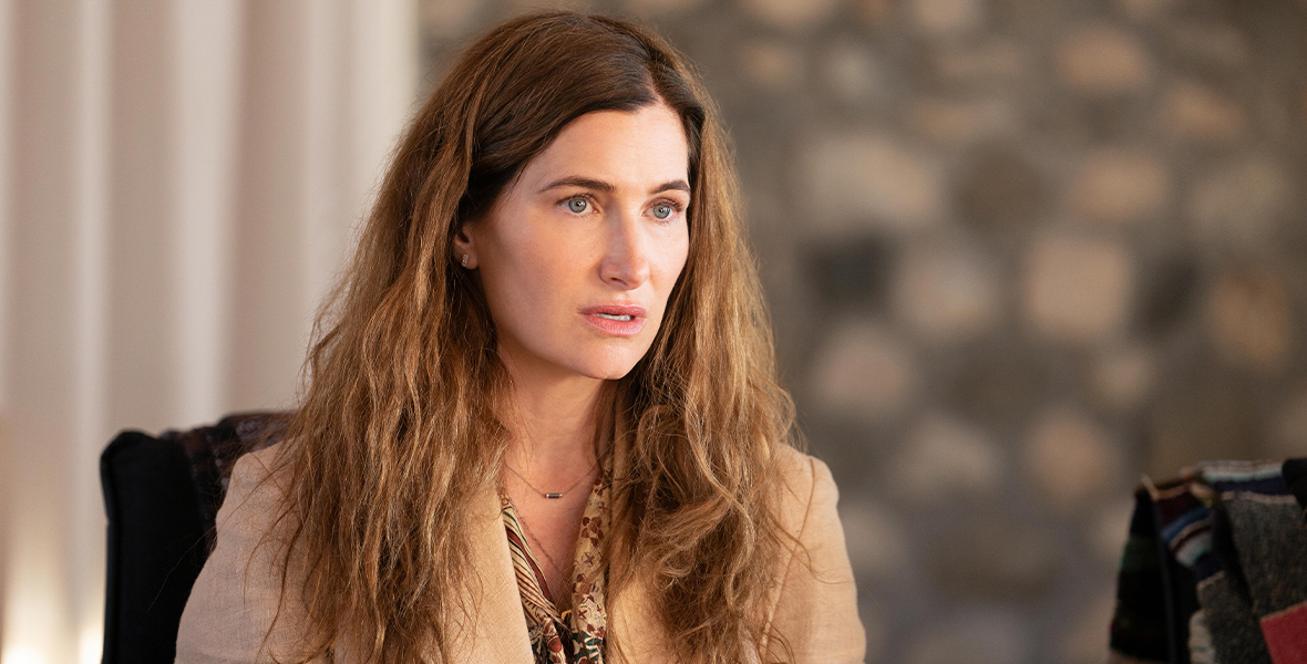 In a scene from Tiny Beautiful Things, Kathryn Hahn stares off camera with a shocked expression.