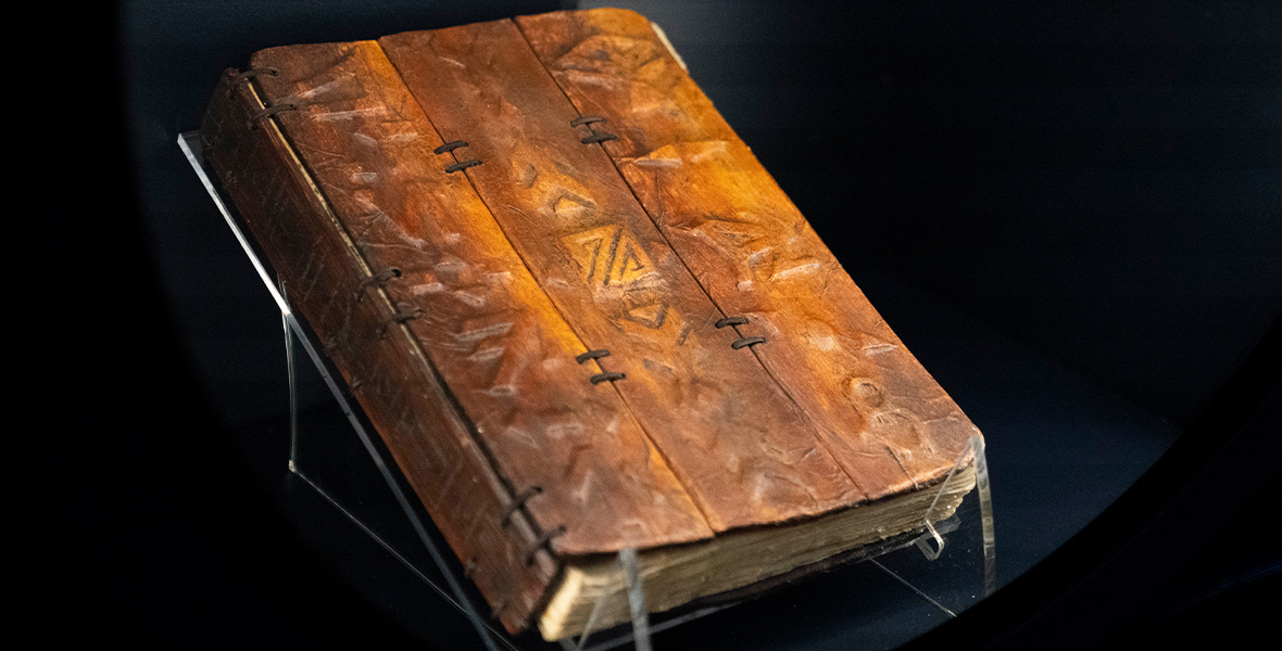 A close-up of the Ancient Jedi Texts, a brown leatherbound book with mysterious text inscribed on the cover.