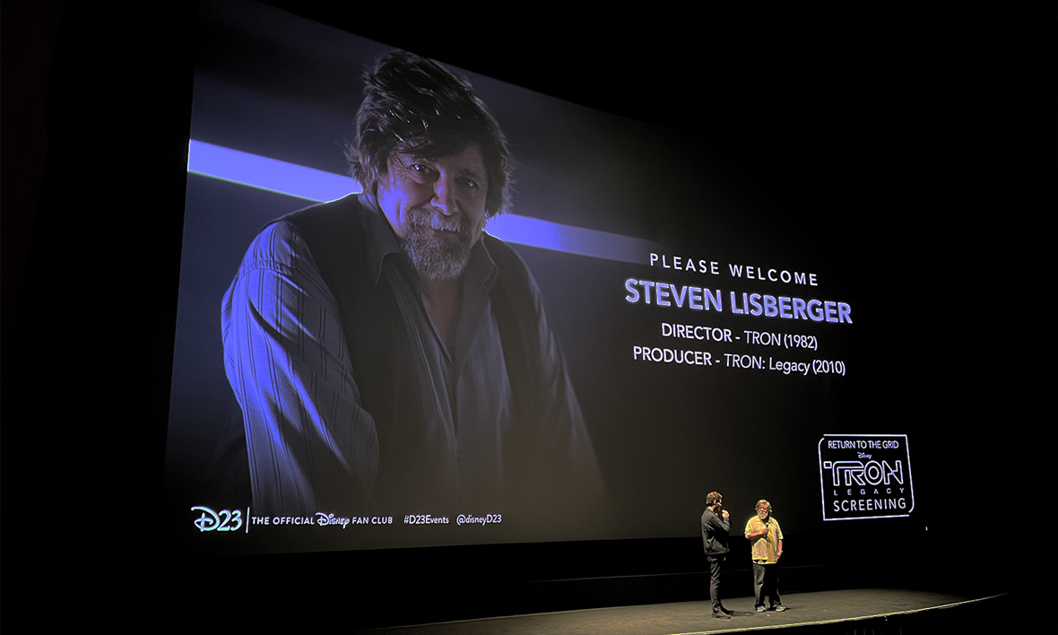 The legendary director of TRON (1982) and producer on TRON: Legacy(2010) Steven Lisberger stands onstage in front of a movie screen, answering questions and regaling audiences with stories of his favorite memories from the Grid.