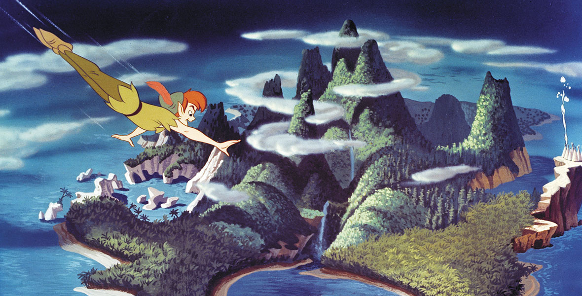 A view of Never Land in the animated film Peter Pan. Peter flies through the sky over the island, which is made of tall mountains, blue waterfalls, and lush greenery. A pirate ship is docked in a bay, while a rocky lagoon is carved into the left side. Clouds fill the sky.