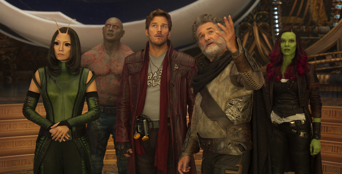 In a scene from Guardians of the Galaxy Vol. 2, actors Pom Klementieff, Chris Pratt, Zoe Saldaña, and Dave Bautista stand around actor and Disney Legend Kurt Russell. 