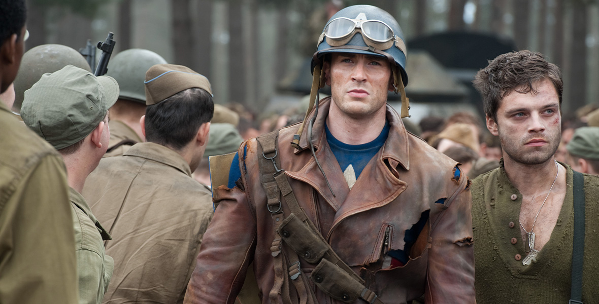 In a scene from Captain America: The First Avenger, actor Chris Evans plays Steve Rogers/Captain America and wears a brown leather coat over his Super Hero suit; he walks alongside actor Sebastian Stan, who plays Bucky Barnes.