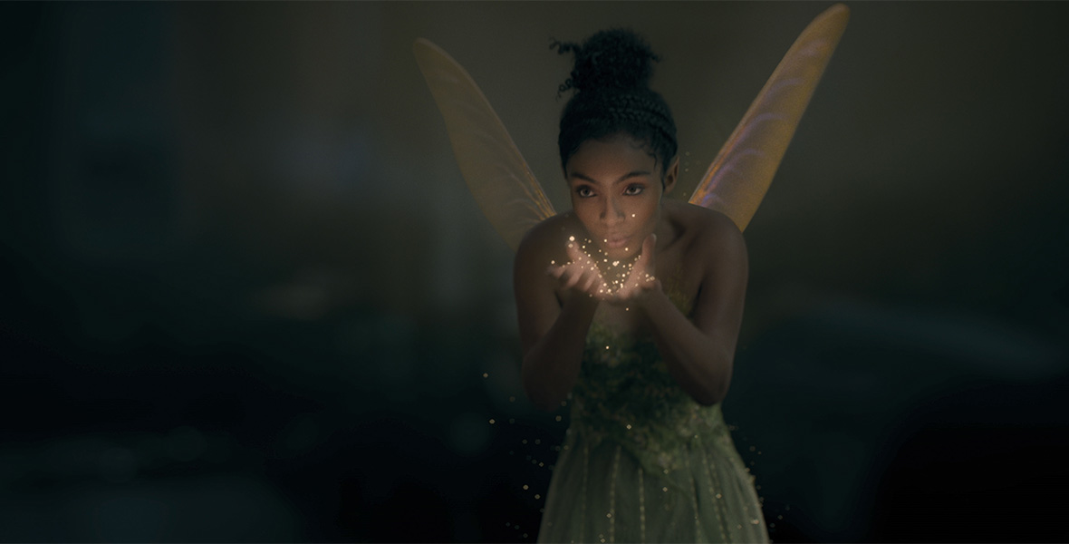 In a scene from Peter Pan & Wendy, actor Yara Shahidi plays Tinker Bell and blows pixie dust into her hands.