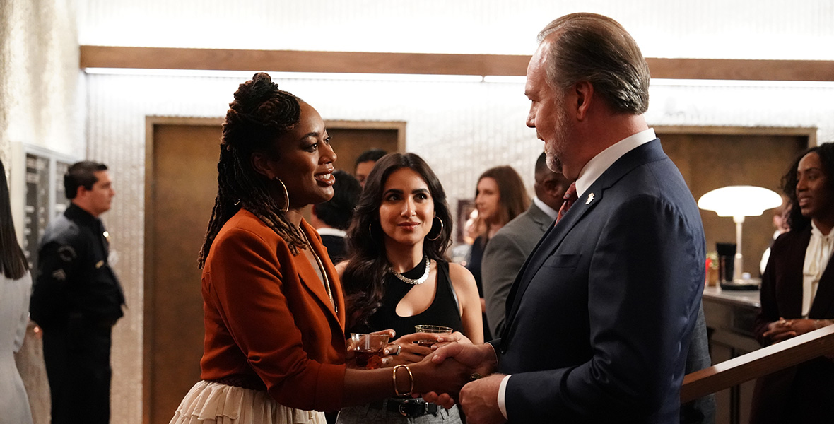 In a scene from Good Trouble, actors Zuri Adele and Rob Nagle shake hands at a party while actor Yasmine Aker stands to the left of Adele.
