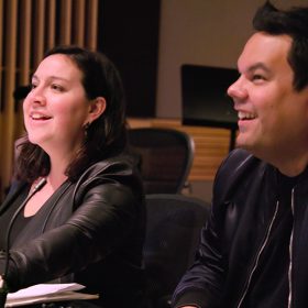 Kristen Anderson-Lopez and Robert Lopez smile in the recording studio.