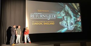 A passionate audience sits in their seats as they watch an informative pre-show before the Return of the Jedi screening begins.