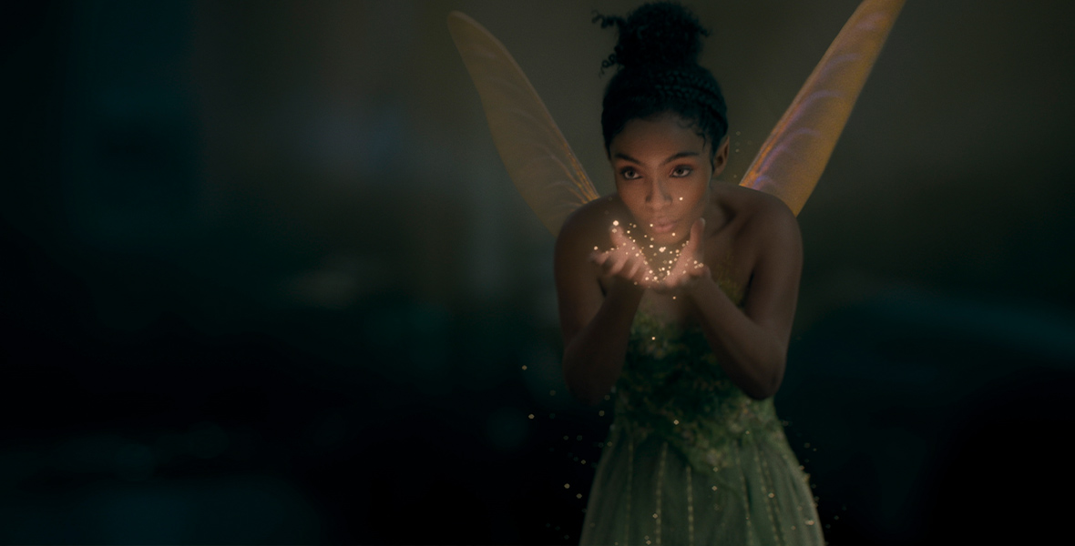 The fairy Tinker Bell (Yara Shahidi) blows gold pixie dust out of her hands.