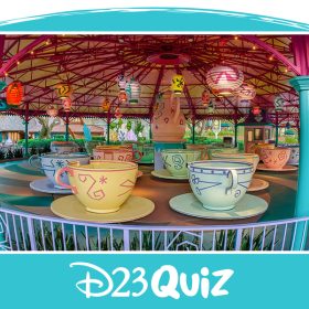A wide angle shot shows the Mad Tea Party attraction at Walt Disney World’s Magic Kingdom. The attraction is empty, there are no people around, and the tea cups are sitting underneath illuminated paper lanterns, but sunlight can be seen beyond the edges of the attraction’s canopy.