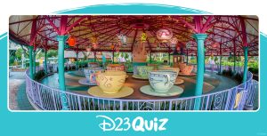 A wide angle shot shows the Mad Tea Party attraction at Walt Disney World’s Magic Kingdom. The attraction is empty, there are no people around, and the tea cups are sitting underneath illuminated paper lanterns, but sunlight can be seen beyond the edges of the attraction’s canopy.