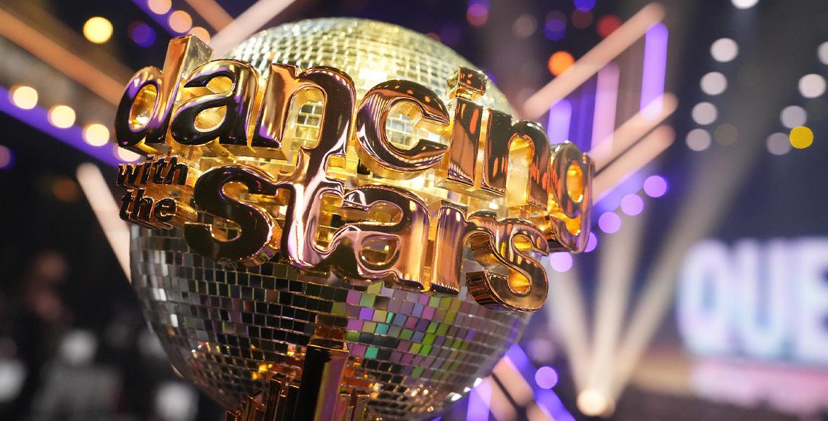 An image of the mirrorball trophy from ABC’s Dancing with the Stars. The ballroom of the long-running series, as well as the set’s lighting, can be seen behind it.