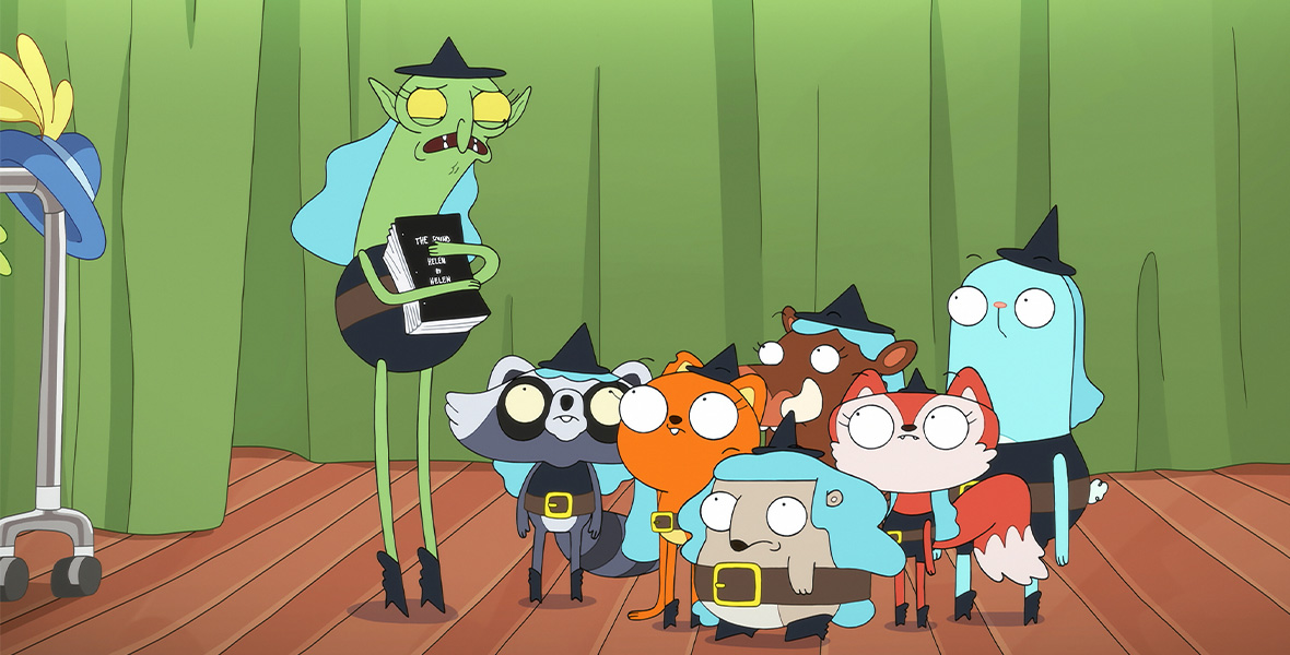 In a scene from Kiff, animated squirrel Kiff alongside other woodland animals stand on a stage and wear black witch hats.