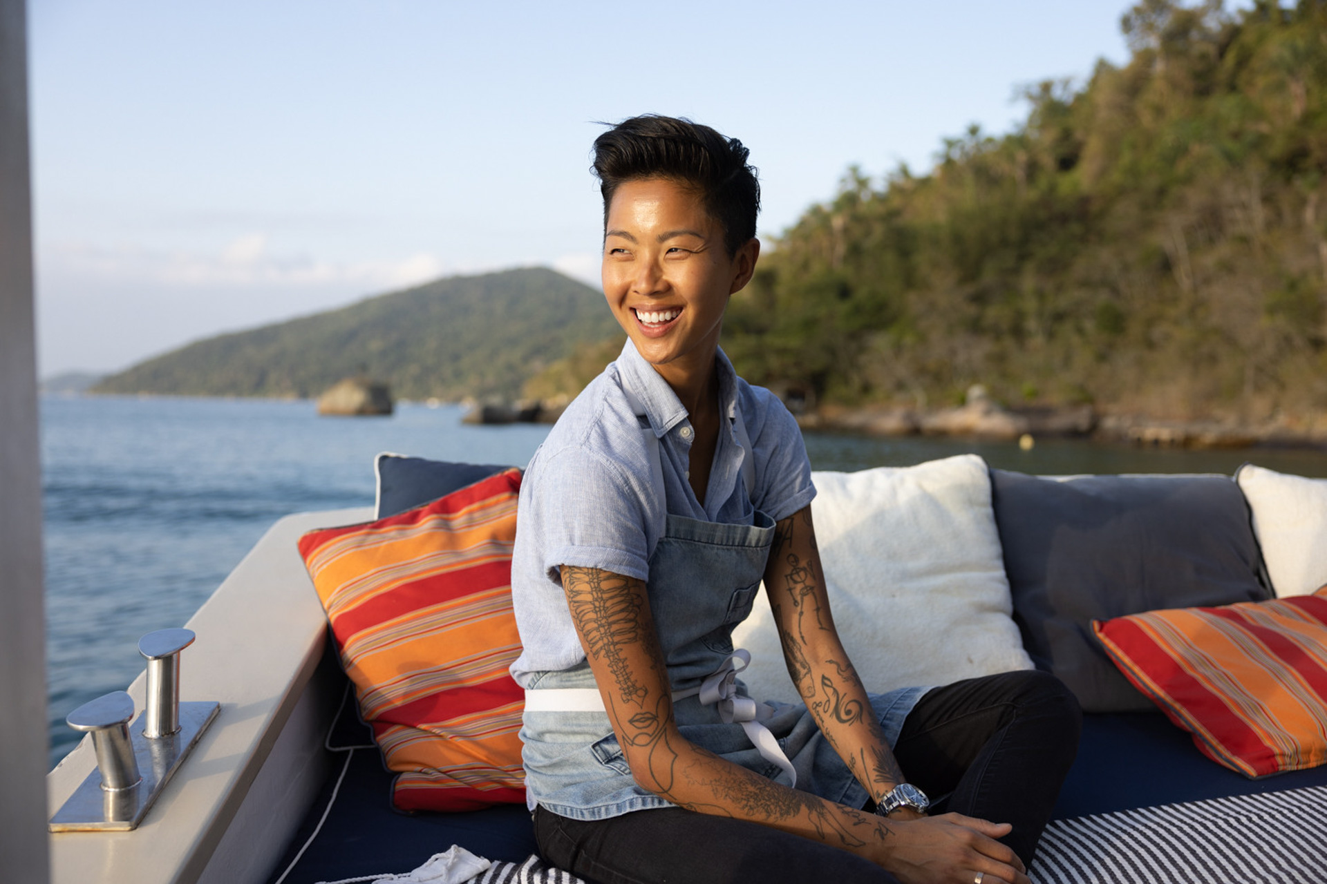 In a scene from Restaurants at the End of the World, chef Kristen Kish sits on the side of a boat.