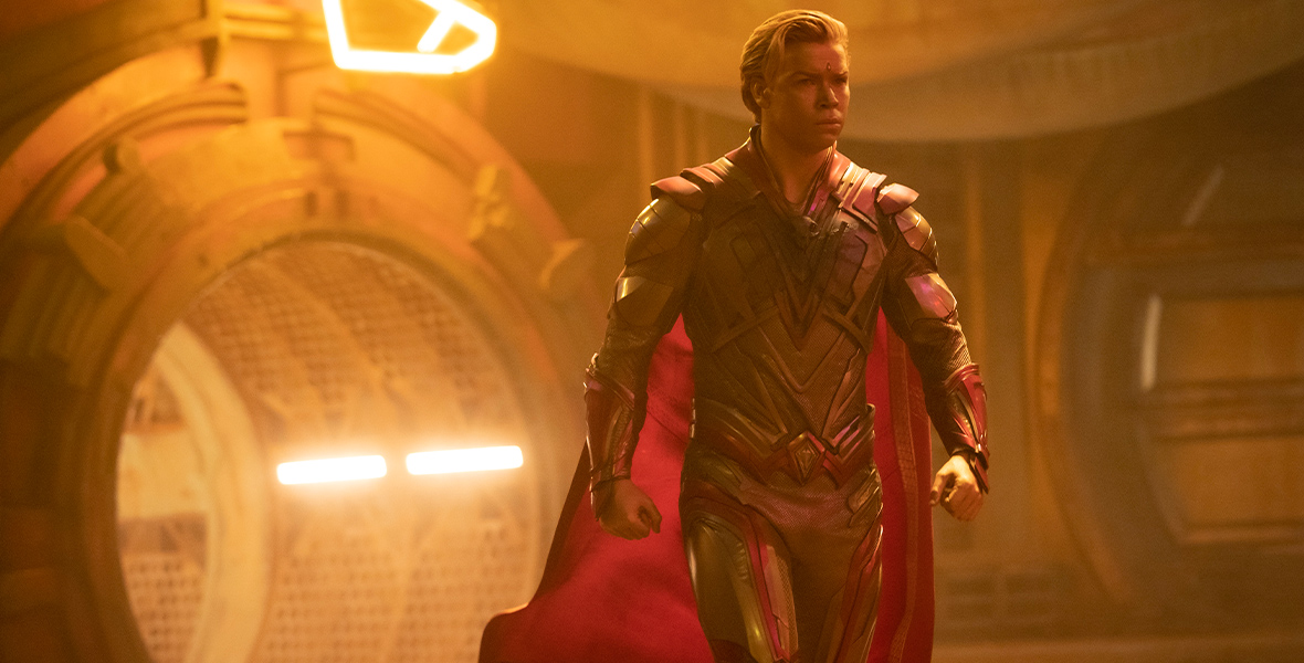 In an image from Marvel Studios’ Guardians of the Galaxy Vol. 3, Adam Warlock (Will Poulter) is walking with purpose in some sort of spaceship toward something to the right, offscreen. A cape billows behind him, and his hands are clenched into fists. His skin shimmers with a golden hue.