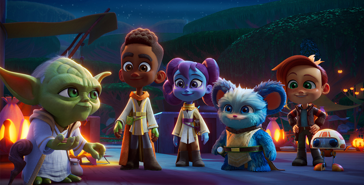 In an image from Lucasfilm’s Star Wars: Young Jedi Adventures, from left to right, Master Yoda stands with Jedi Younglings Kai Brightstar, Lys Solay, and Nubs and their friends Nash Durango and RJ-83 on planet Tenoo. It’s nighttime; some lamps are seen behind the group, as are some hills in the distance.