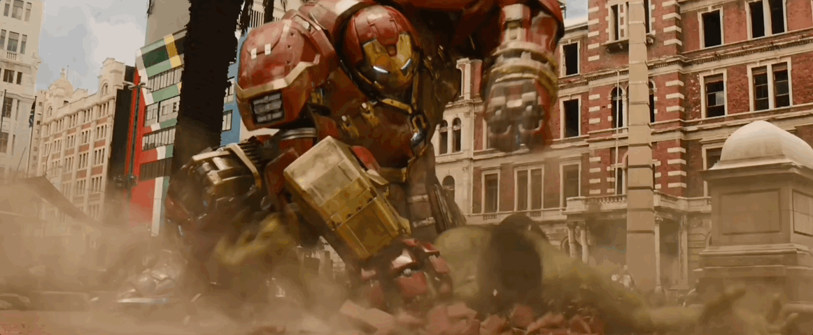 In the town square, The Hulkbuster repeatedly punches The Hulk in the face.