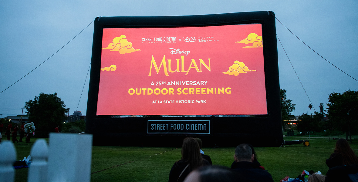 Outdoor Projection Screen for Mulan 25th Anniversary Screening with D23, featuring the film logo inside of the LA State Historic Park”