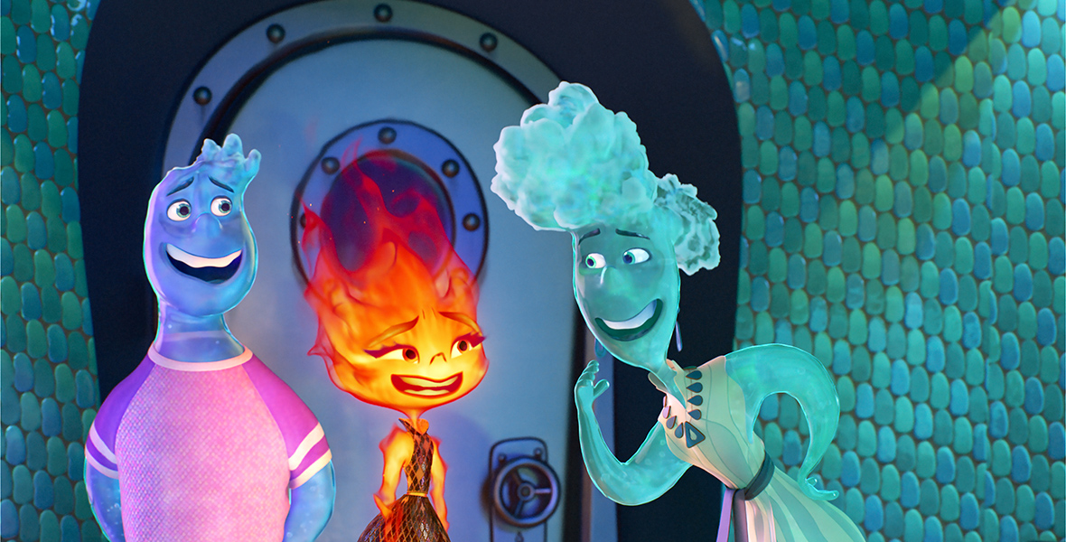 In this image from Disney and Pixar’s Elemental, Wade, a Water person (voiced by Mamoudou Athey), on the left, and Ember, a Fire person (voiced by Leah Lewis), in the center, stand talking to Brook (Catherine O’Hara), who is Wade’s mother. They’re standing in the hallway of Brook’s family condo in front of a metal door that resembles the hatches on a submarine. It’s the entrance to the condo and is surrounded by a wall tiled in blue-and-green stones.
