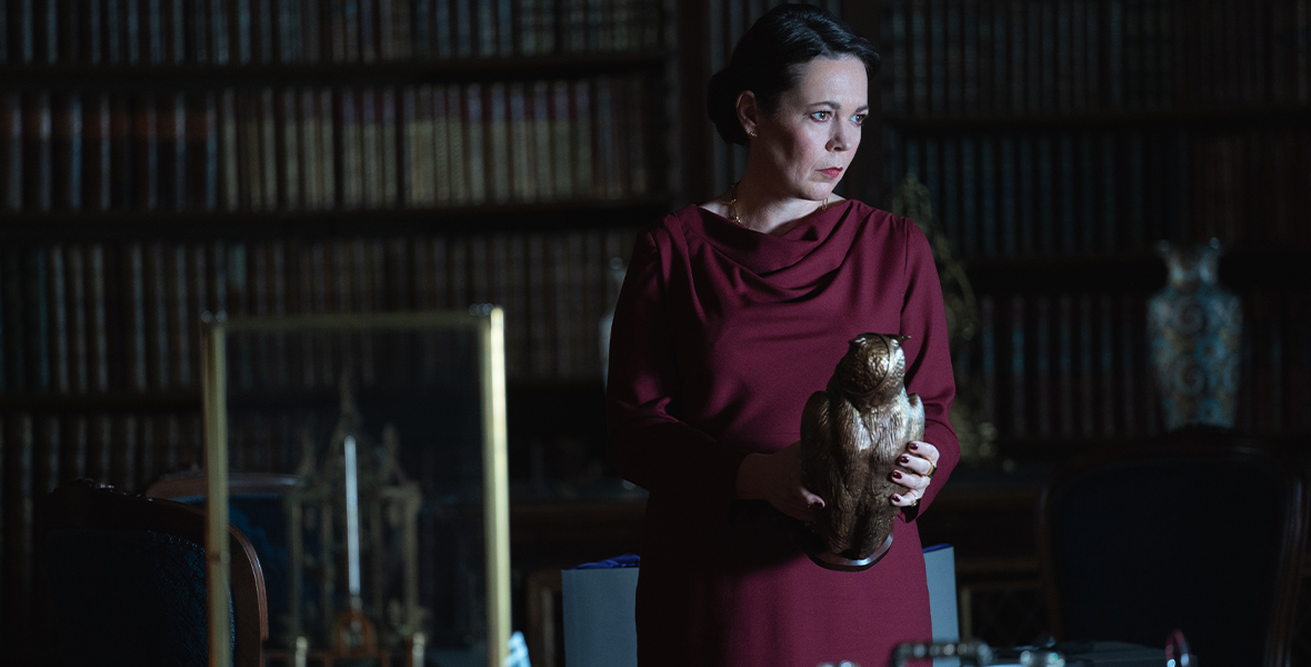 Sonya Falsworth (Olivia Colman) stands in a library and holds a wooden owl.