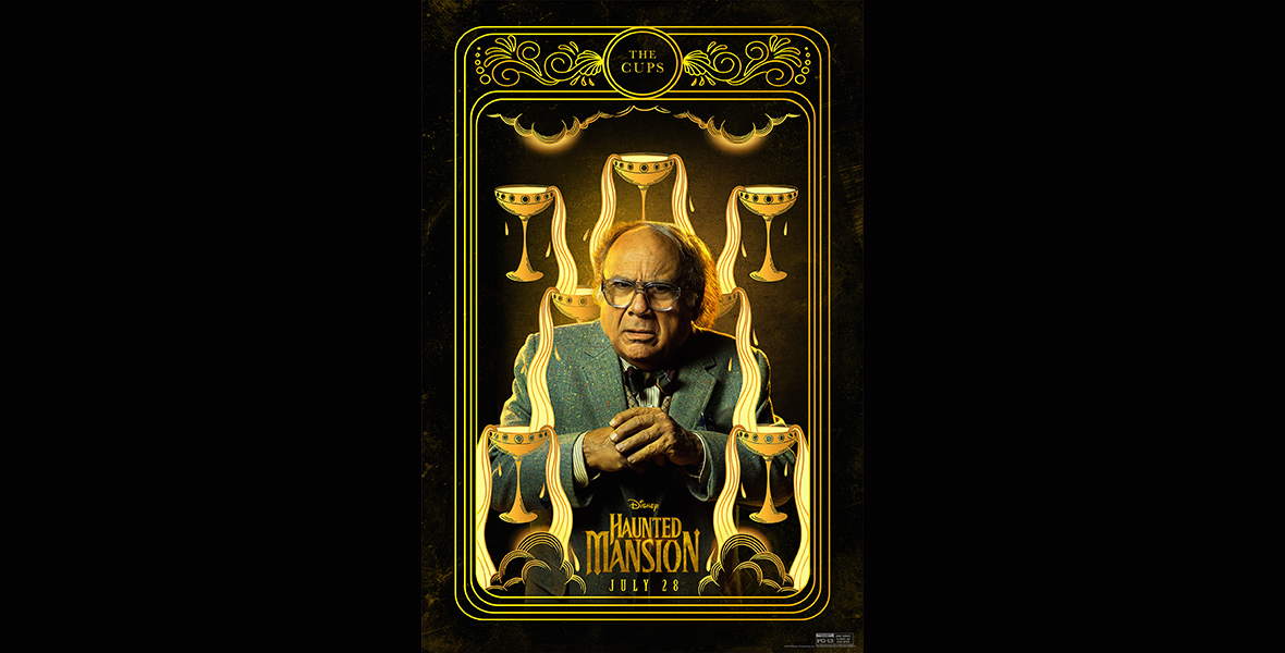 In a promotional image from Disney’s Haunted Mansion that looks like a tarot card for “The Cups,” Professor Bruce Davis (Danny DeVito) is looking concerned, with his hands clasped, surrounded by yellow-hued cups that have drawn depictions of golden liquid pouring out of them, all set against a black background. He is wearing glasses, a bow tie, and a suit jacket. The logo for the film is at the bottom of the image, along with the date of the film’s release.