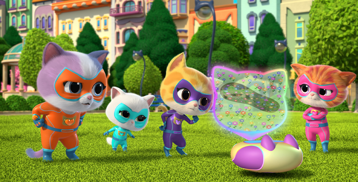 In an image from Disney Branded Television’s SuperKitties, Buddy (voiced by JeCobi Swain), Bitsy (voiced by Pyper Braun), Sparks (voiced by Cruz Flateau), and Ginny (voiced by Emma Berman) stand next to the SuperKitty Kit on a grassy field in front of a row of houses, other buildings, and trees. They are looking intently at the Kit.  