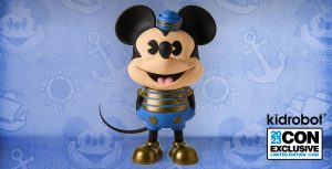 A vinyl figure of Mickey Mouse in a blue and gold sailor suit, with the kidrobot logo in the corner, along with text denoting it&rsquo;s a 2023 Comic-Con Exclusive.