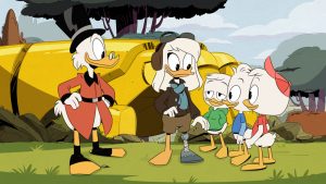 Della Duck stands in aviator gear, outside her rocket. Her right leg is a prosthetic she made out of rocket materials so she could get home from her mission to the moon. Her three duckling sons stand to her right with pleased expressions, while Scrooge McDuck stands to the left.