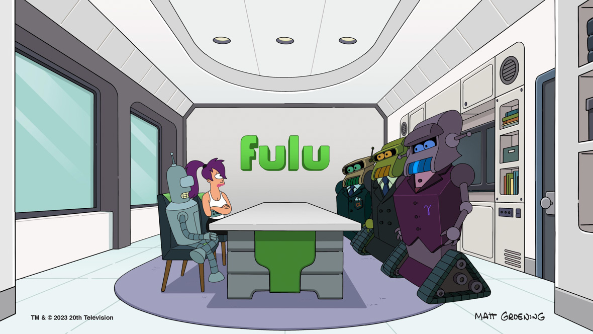 In an image from Hulu’s Futurama, Bender (voiced by John DiMaggio) and Leela (voiced by Katey Sagal) are sitting in a futuristic looking conference room, at a table across from several menacing looking robots. At the back of the room, on the wall, is a large logo that resembles the Hulu logo, except it reads “Fulu.” A large window is seen to the left; a bookcase with a television is seen behind the robots to the right. The signature of the show’s creator, Matt Groening, can be seen at the bottom right of the image.