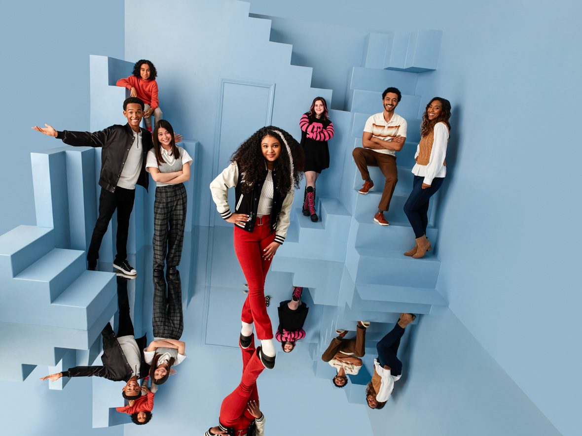 In a promo image for Disney Branded Television’s Pretty Freekin Scary are Kyan Samuels as Pretty, Yonas Kibreab as Remy, Leah Mei Gold as Scary, Eliana Su’a as Frankie, Emma Shannon as Nyx, Shawn Carter Peterson as Mr. Ripp, and Napiera Groves Boykin as Mrs. Ripp. They’re standing in a room that appears to have a mirror as a floor, as it features mirrored images of the actors. The room is painted entirely light blue and contains a door and several sets of stairs that go nowhere, like a funhouse.