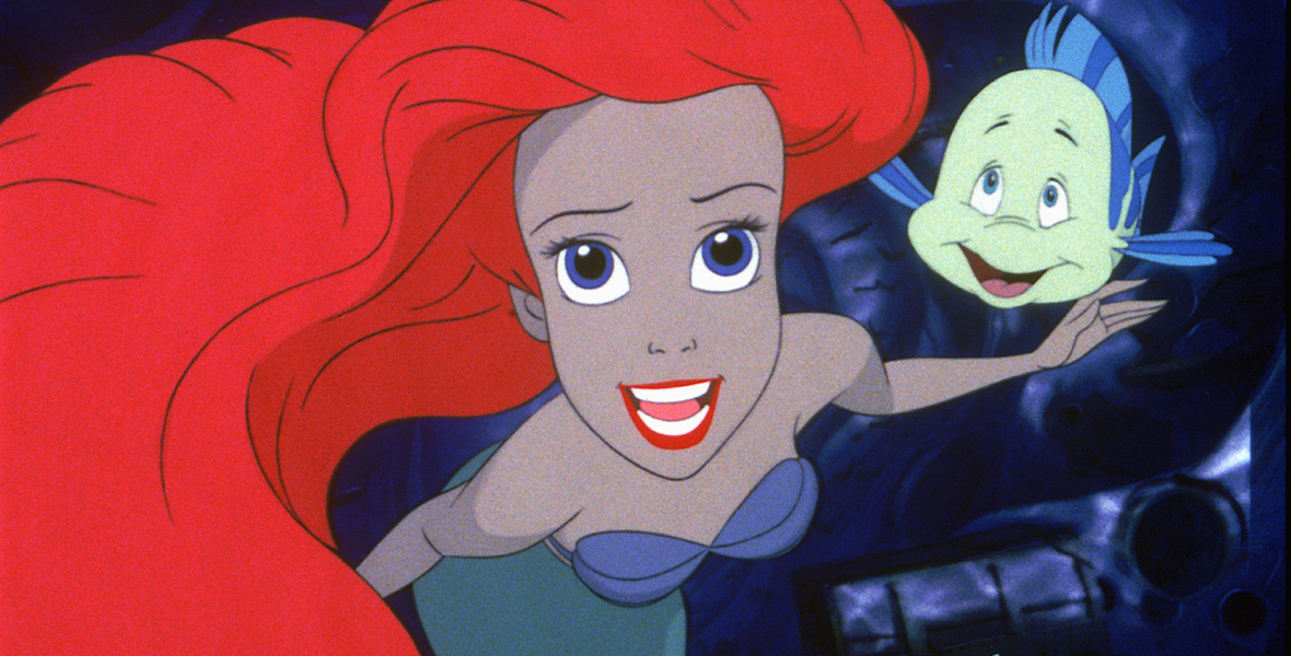 Ariel, from the film The Little Mermaid, is wearing a purple top and is looking straight up during the “Part of your World” song. with flounder right behind her, looking at her.