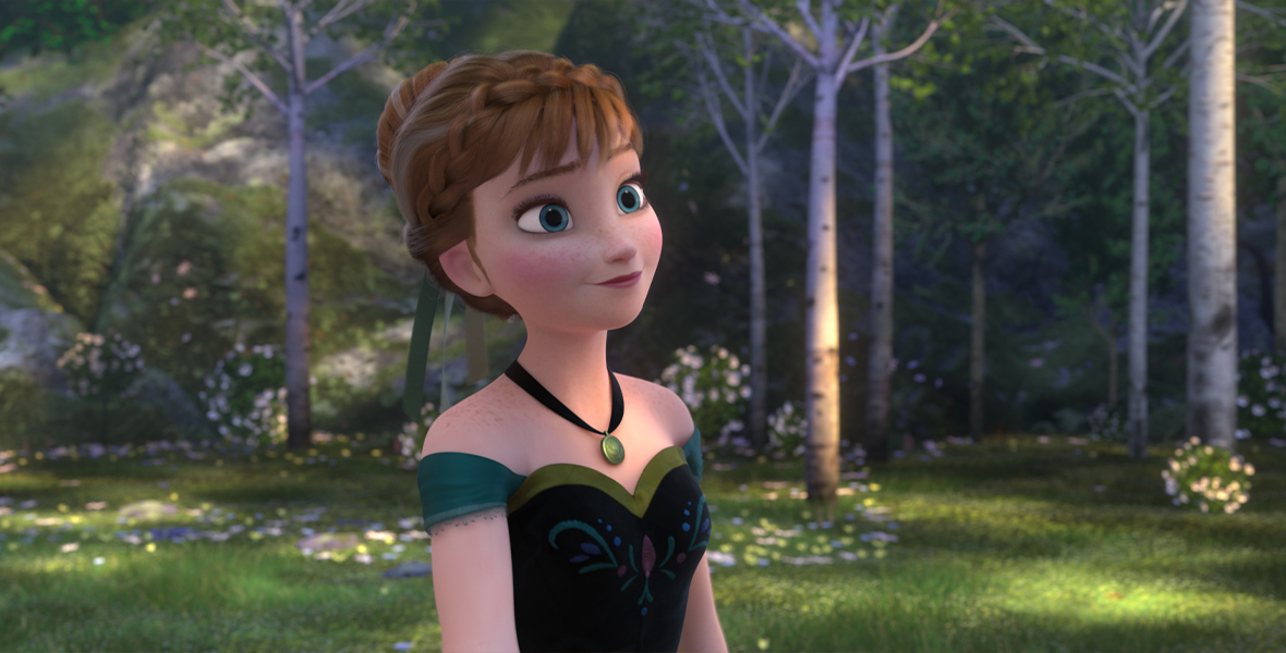 Anna, from the film Frozen, is standing in a forest with green grass and purple and white flowers while wearing a black necklace with a green pendant, and a dress with a black bodice that has a green and red design, green off the shoulder cuff sleeves, and a light green rim on the top. Her hair is up in a bun with a braid around her head and a green bow tied into her bun.