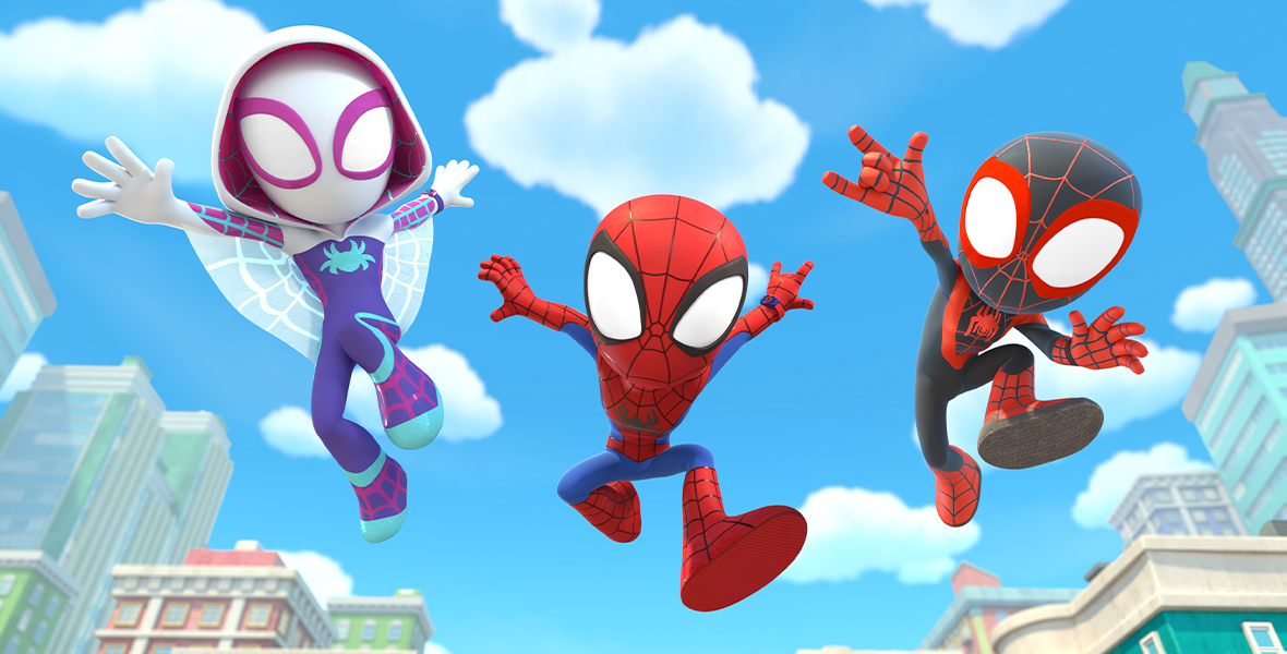 In an image from Marvel’s Spidey and his Amazing Friends, from left to right, Gwen Stacey (voiced by Lily Sanfelippo), Spidey/Peter Parker (voiced by Benjamin Valic), and Miles Morales (voiced by Jakari Fraser) are flying through the air, toward the camera; there are tall buildings seen behind them. It is daytime.