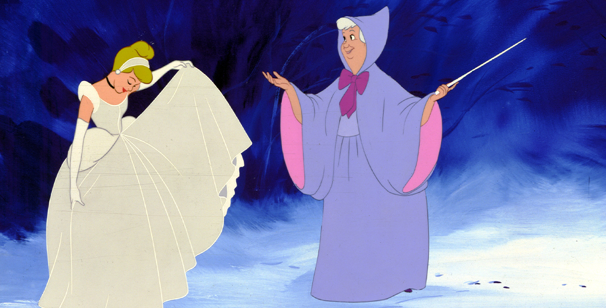 In an image from Disney’s 1950 animated classic Cinderella, the Fairy Godmother has just turned Cinderella’s simple dress into a beautiful shimmering ballgown. The Fairy Godmother herself is in her iconic periwinkle dress with a hood and a pink bow at the neck, and she’s holding a wand.
