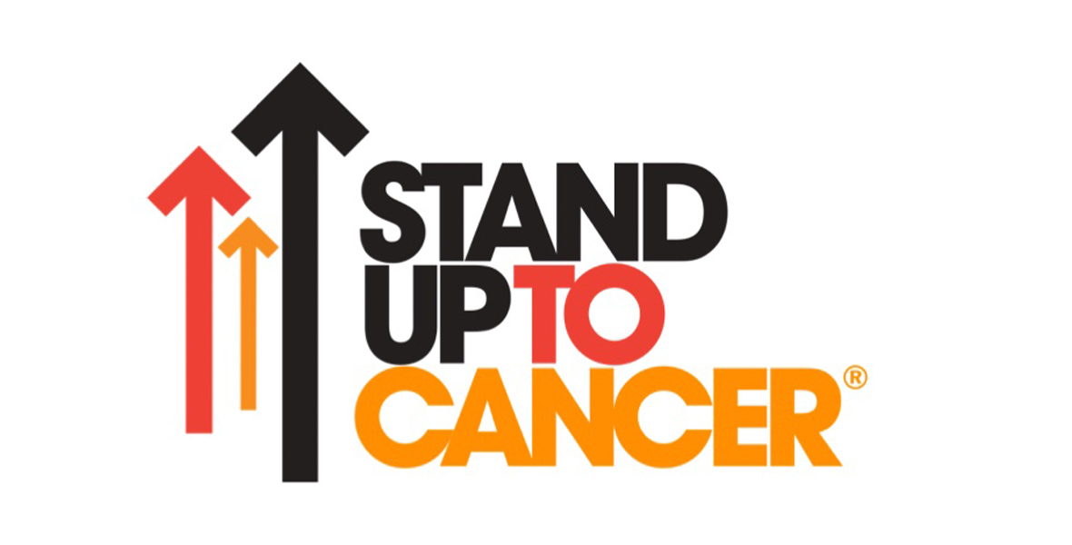 The logo for Stand Up To Cancer, in black, red, and yellow, features several arrows on the left of the image that point up.