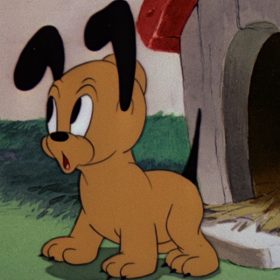 Pluto Junior's ears and eyes are raised as he exits his doghouse.