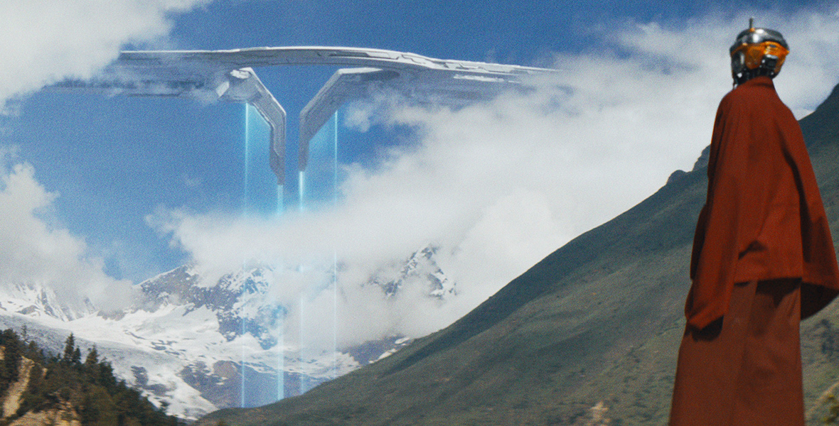 In the foreground, AI wearing a red monk-like robe looks into the distance. In the background, a futuristic space ship in the clouds emits two beams of blue light into a valley.